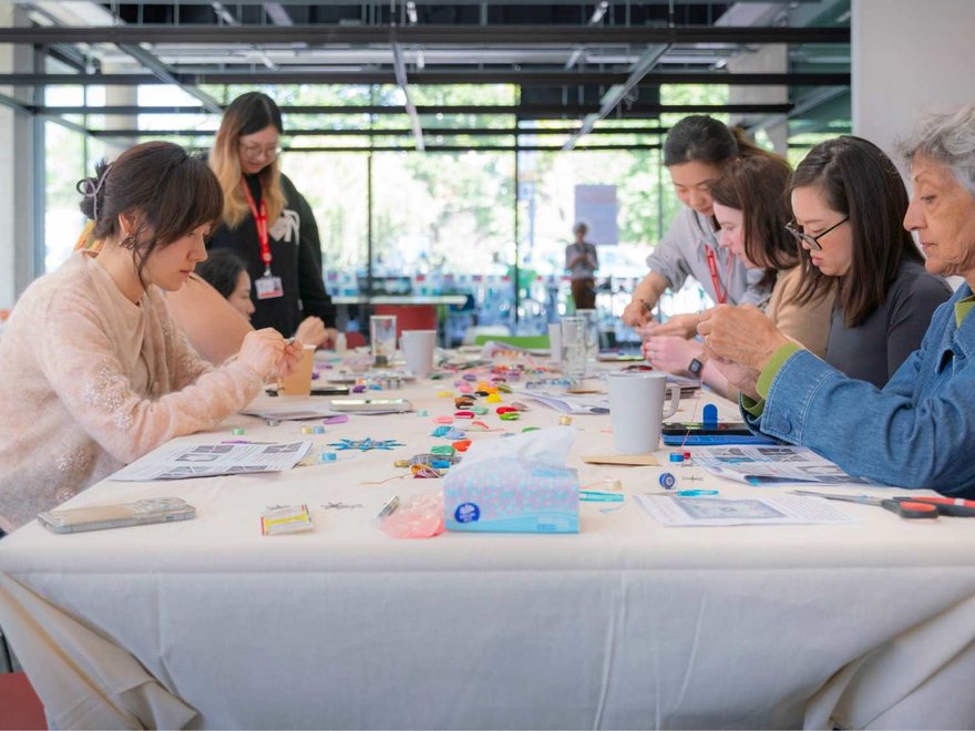 people sit at a crafting table crafting