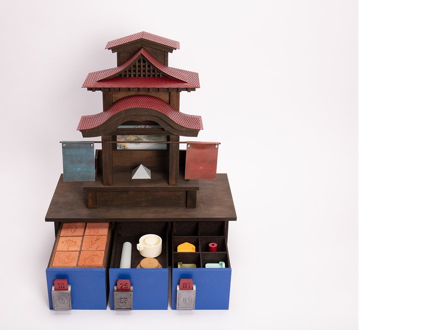 Wooden model of a Japanese temple with small draws underneath