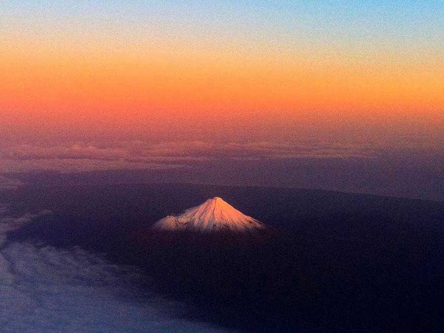 Ariel view of a snow capped conical mountain