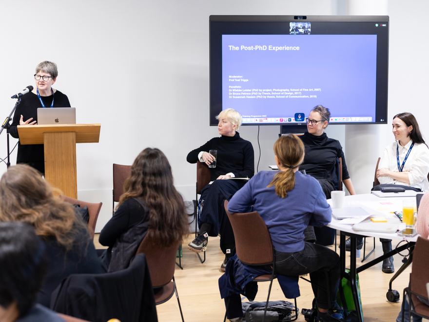 A woman delivers a talk to a crowded room