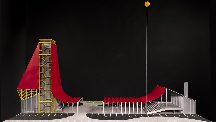 An architectural rendering of a modern structure featuring a long, red, undulating slide-like element that connects a tall, yellow framed tower on the left to a lower building on the right.