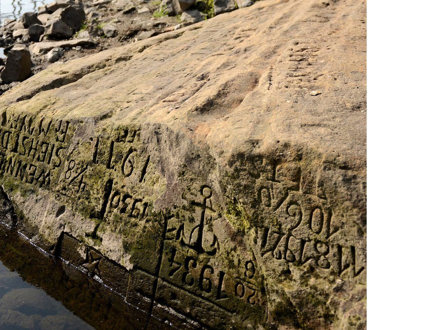 A stone riverbank of the Elbe river, Děčín, Czech Republic, with words enscribed.