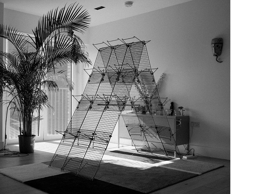 A sculpture in the shape of an a-frame made of wire mesh.