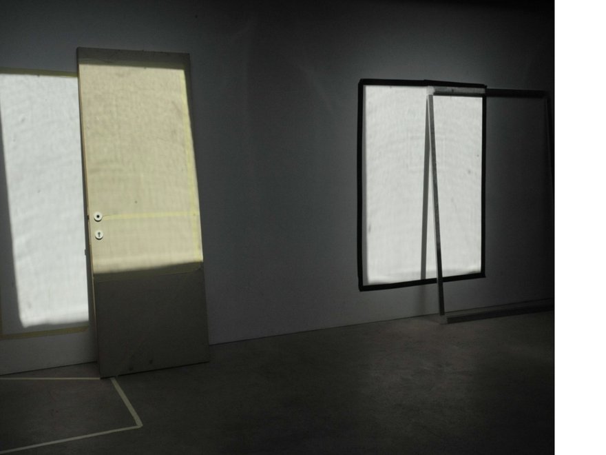 Installation view of several canvas panels leaning against a wall.