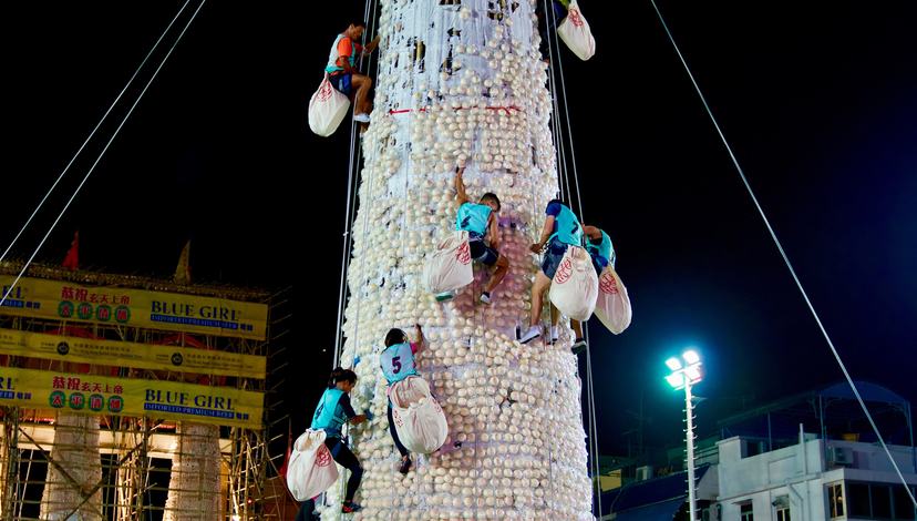 Competitors in ‘Bun Scrambling Competition’ climb bamboo towers and try to collect as many ‘lucky’ buns as possible, Cheung Chau (Hong Kong), 22 May 2018. Photo: Wang Sing