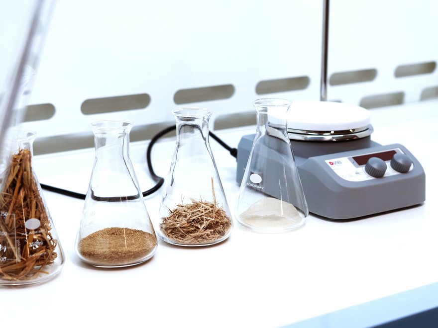 A close up of material samples in flasks and a set of scales.