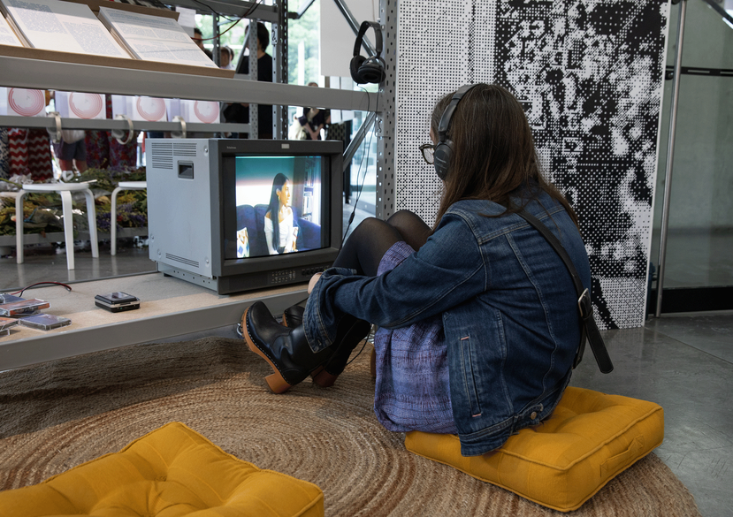A visitor watching a video interview with Nihal El Aasar, 2026, as part of elsewhere, within here, presented as part of the Curating Contemporary Art (MA) Show, Royal College of Art, 2026. Photo: Lucy Veale.