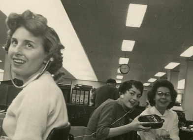 Bonny and two colleagues sat at their desks with their headphones in from her time working as a typist at Ilford Limited, circa 1960s, from the Snapshots Through Time Project, Credit:  Eastside Community Heritage