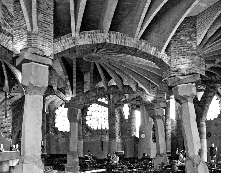 A black and white photograph of the interior of the Crypt of Colònia Güell by Antoni Gaudí.