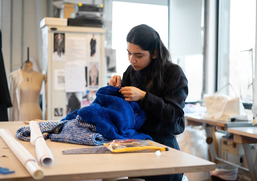 Uroos Jamal working with blue fabric