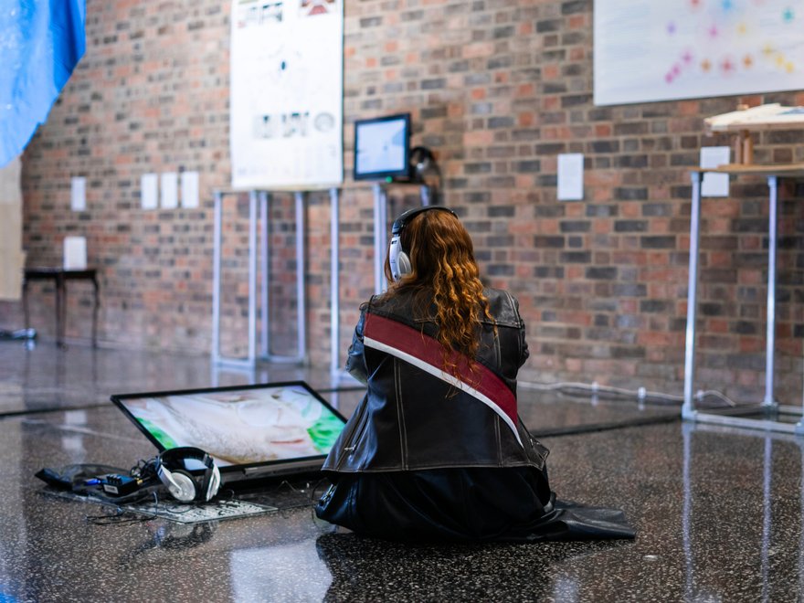 Someone sits and watches TV in a gallery