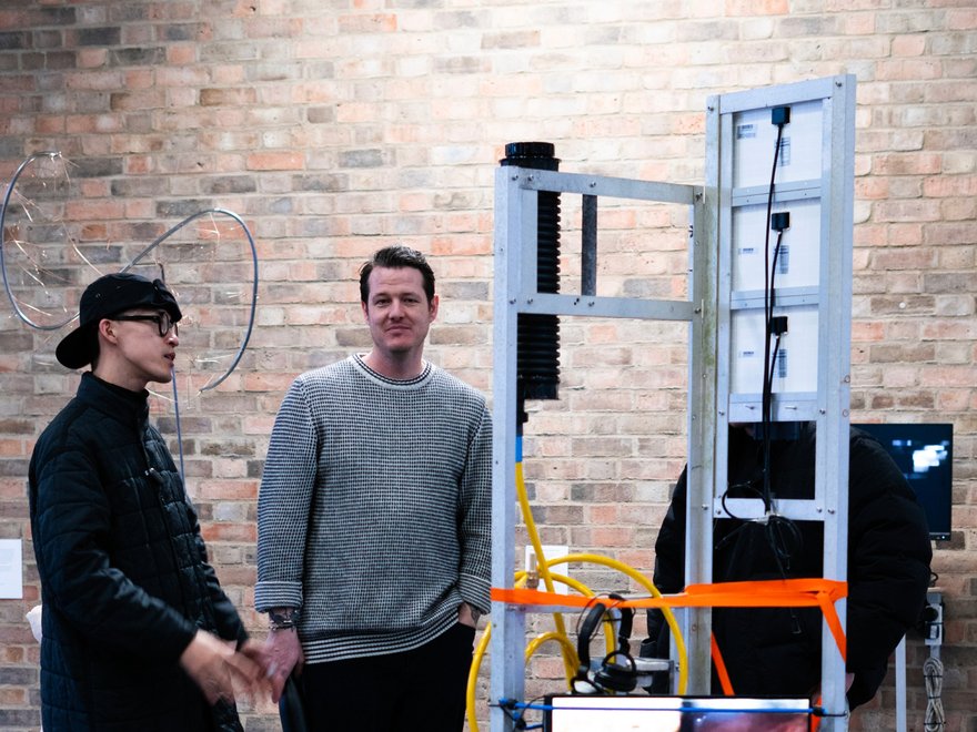 two people stand in front of a sculpture