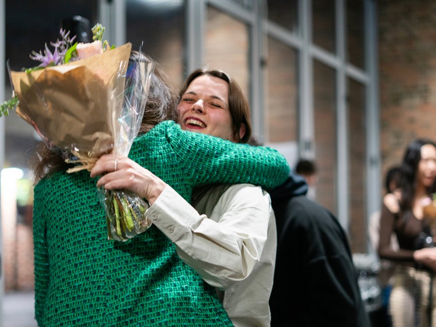 Two people hug with flowers