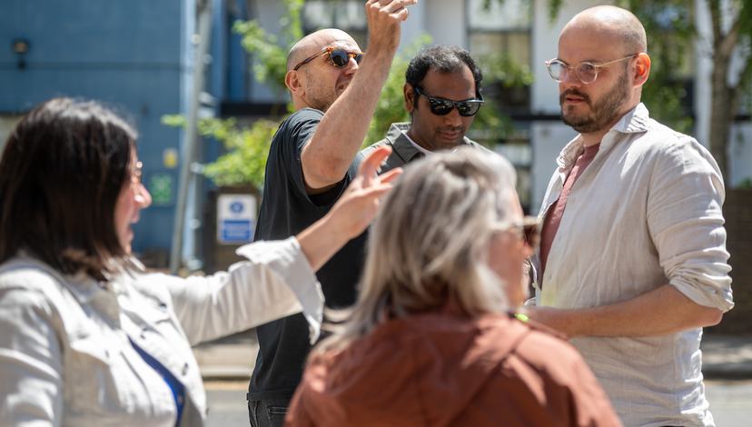 The cohort of 2025 Futures Through Design are outside, working on one of their projects, holding a screenfinder up against the landscapes.