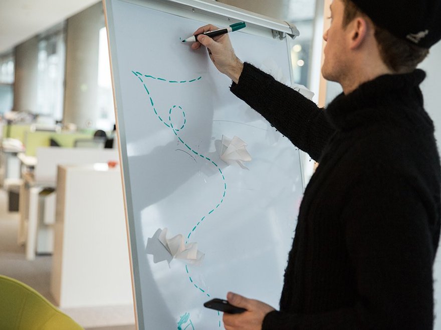 A researcher draws a dotted line on a white board