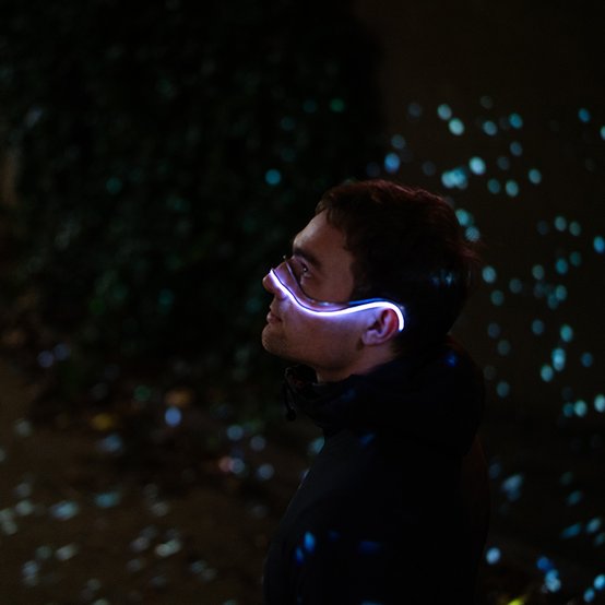 A man poses with the light up Starsight device hung over the bridge of his nose