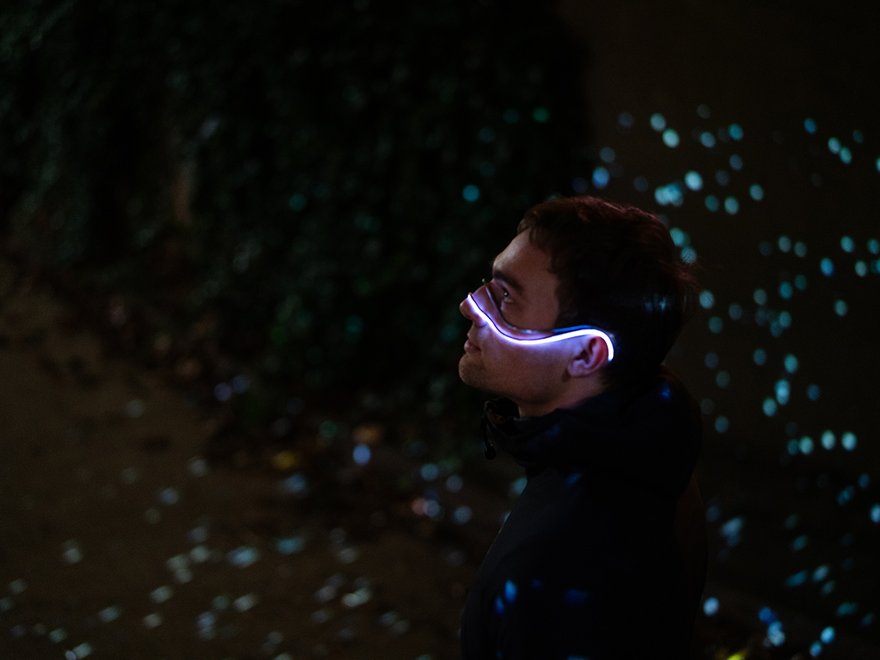 A man poses with the light up Starsight device hung over the bridge of his nose