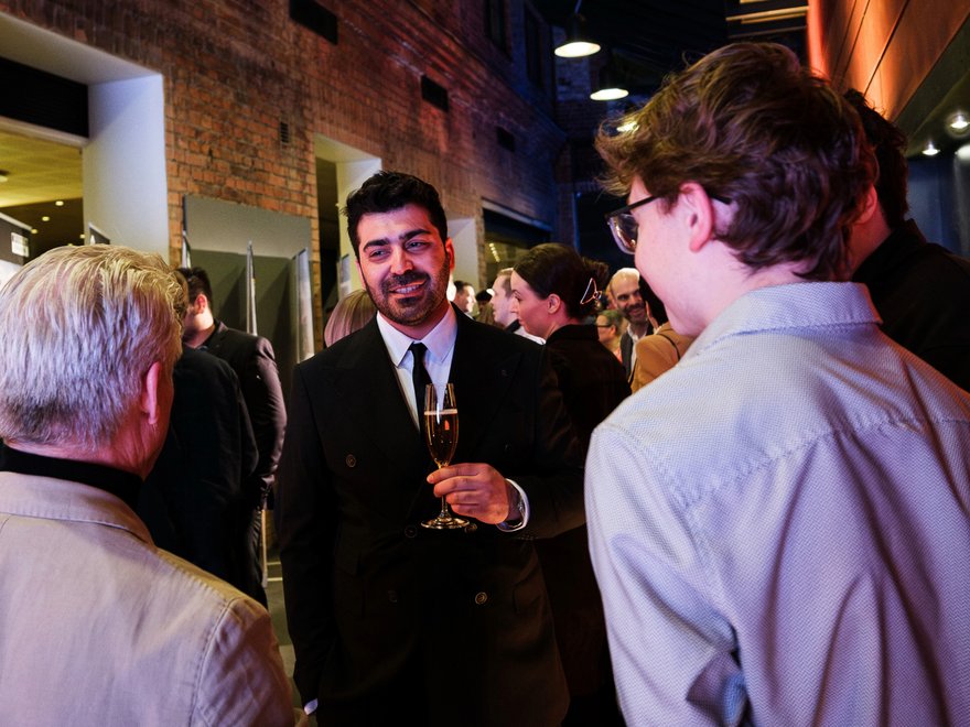 A man talks to other two people at an event