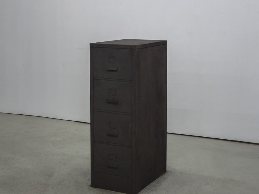 A dark filing cabinet in a grey room