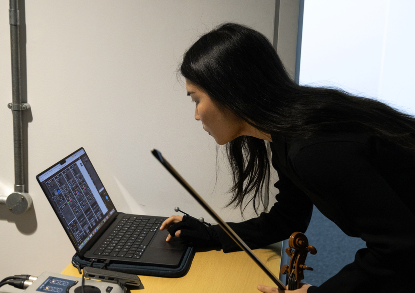 Sue-In Kang working with the AI improvisation system,Somax2, used to generate responsive sound during performance. Photo: Vivaan Thongram