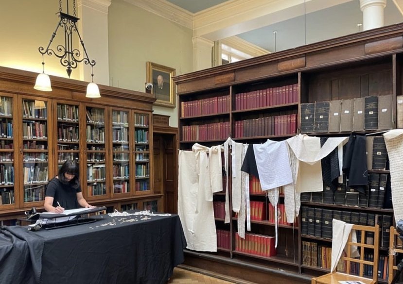 Image from a durational performance at Bishopsgate Institute, July 2023, generously funded by LAHP. Being Seen, Being Heard – cotton fabric, jute rope, ink, iron.