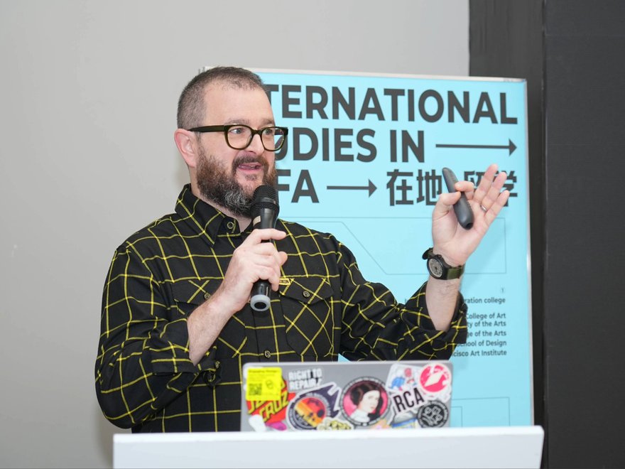 A man delivers a lector with a laptop in front of him