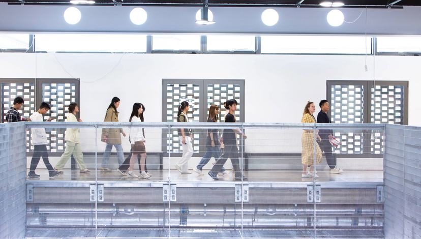 People walk across an internal bridge inside a building