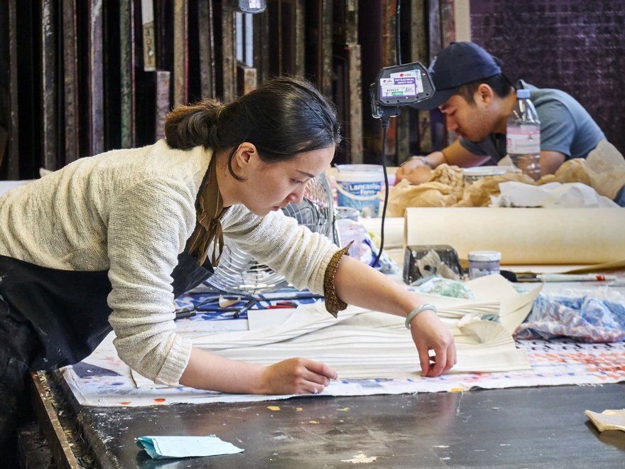 Two students working with fabric in the textiles dye lab