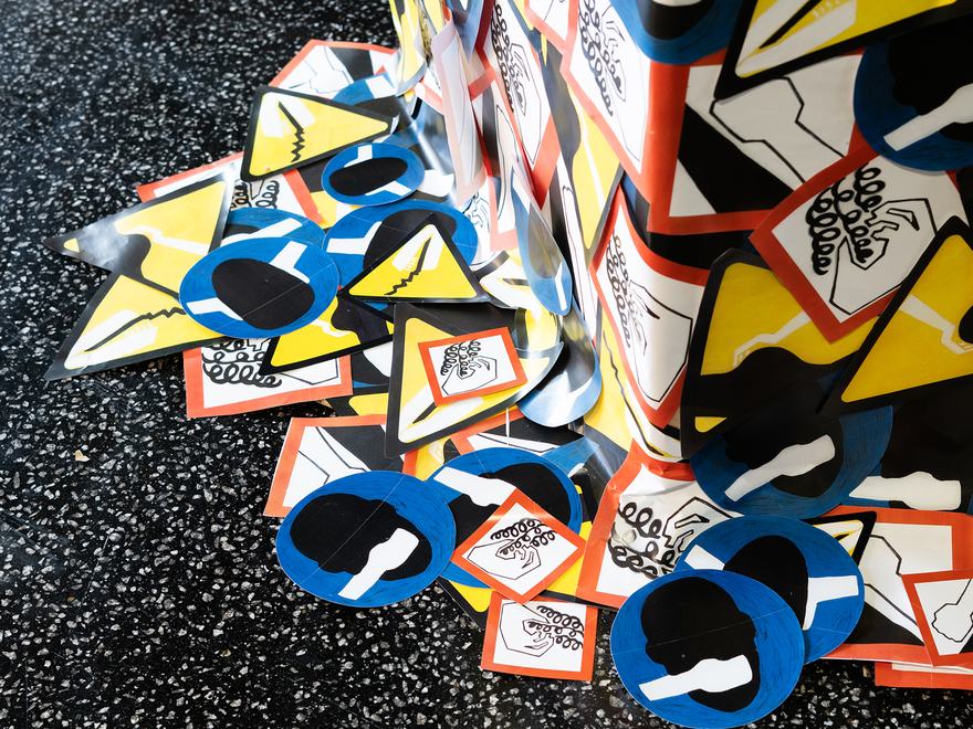 detail of a sculpture with brightly coloured logos on it