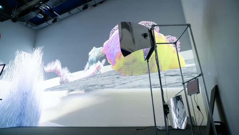 A projector projecting pink and yellow images onto the walls of a big room