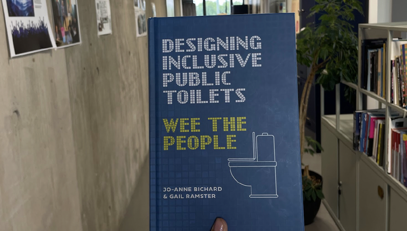 A hand holding a book with a blue cover