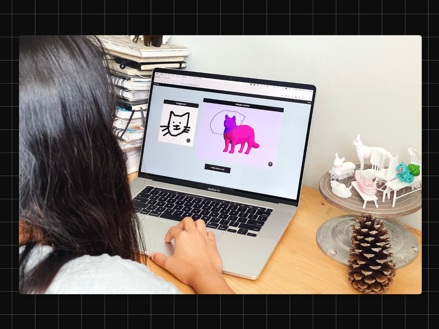 a woman sits in front of a computer doing 3D modelling