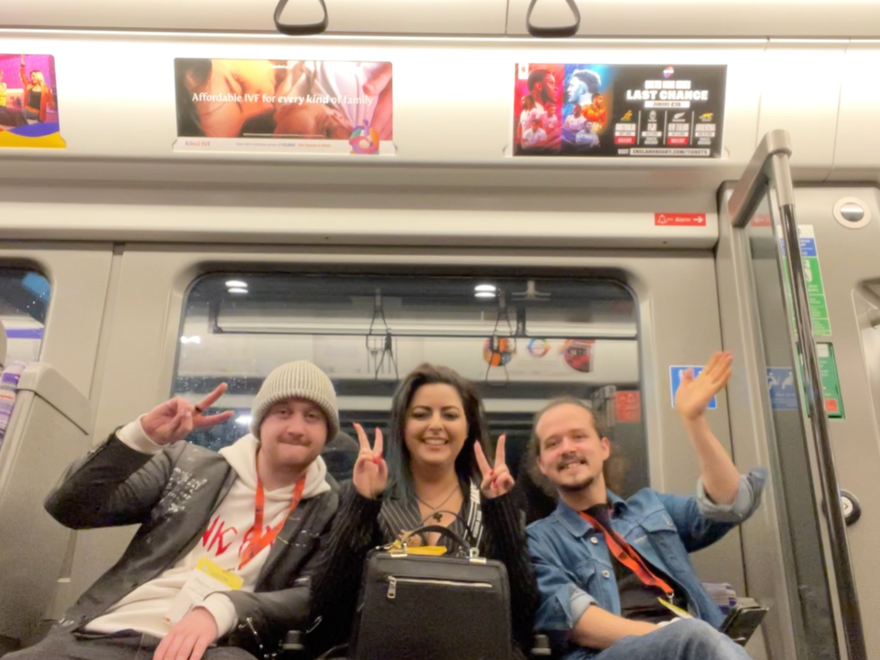 three people sit together on the tube
