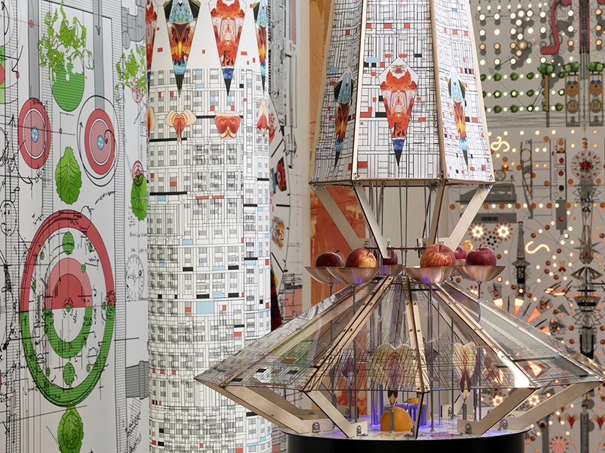 A rendering of a colourful art installation which includes apples and oranges in a device