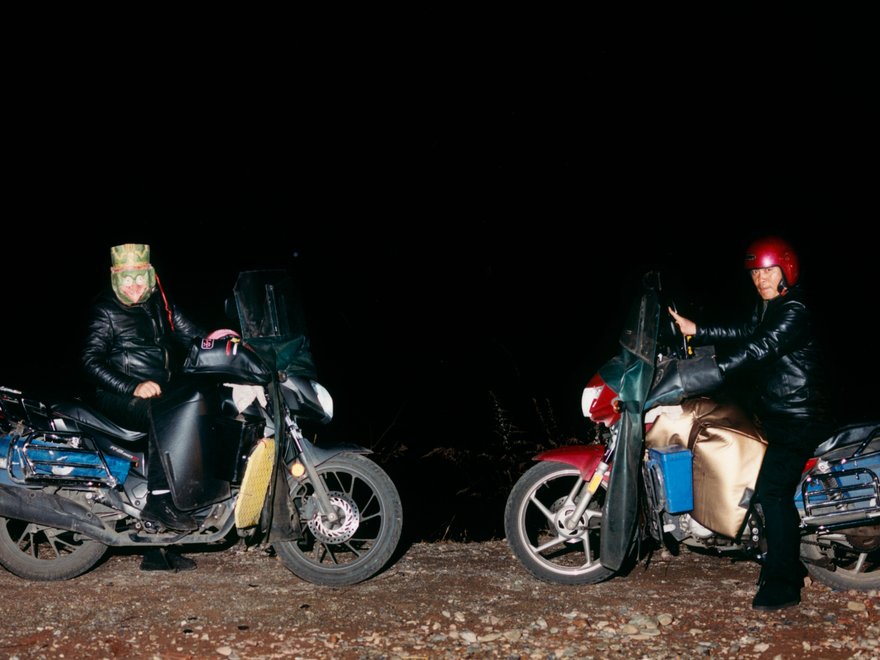 a photo of two people on motorbikes in the dark