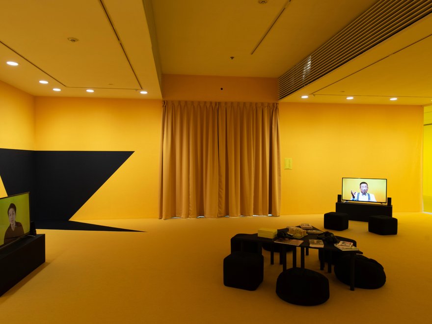 A yellow room with a tv and modern furniture