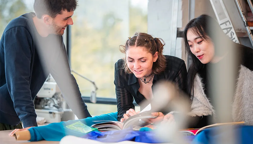 Three students collaboraring on a project